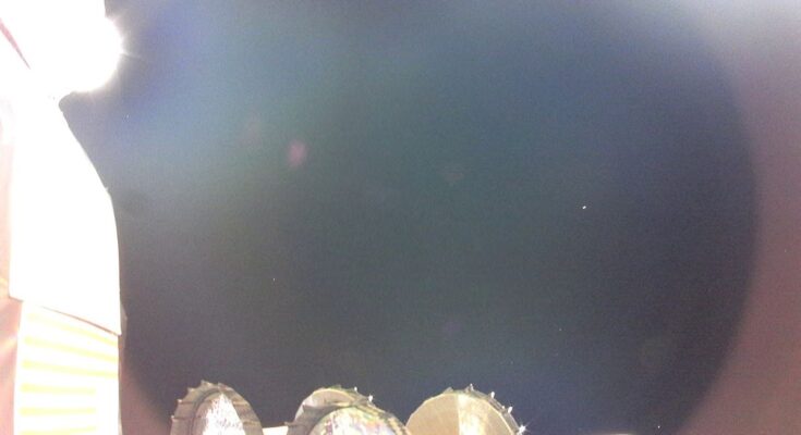 a few pieces of metal equipment can be seen on a spacecraft. most of the image is filled with the blackness of space