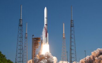 a white and red rocket launches into a blue sky.