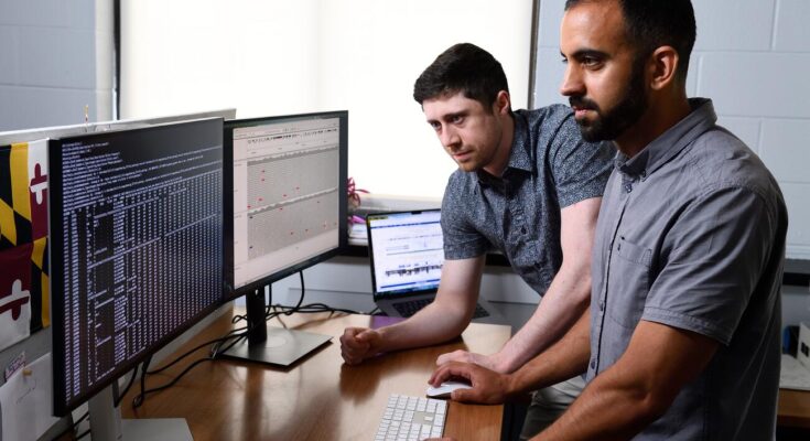 Dylan Taylor (left) and Rajiv McCoy looking into a dataset of genetics data in their computational biology lab.