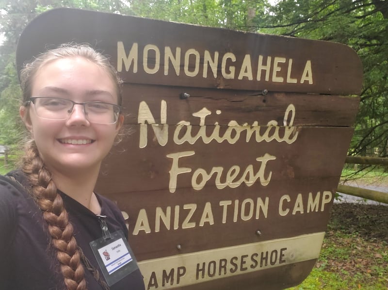 Samantha Dolby Monongahaela realiza un chasquido de selfie con el símbolo del Bosque Nacional el 10 de julio de 2025 mientras estaba en el Campamento Nacional de Ciencias Juveniles en Virginia Occidental.