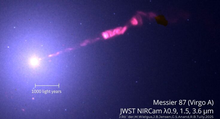 A hazy trail of pink gas is expelled from a bright light representing black hole M87 in the darkness of space with the words "JWST NIRCAM" on the bottom of the image