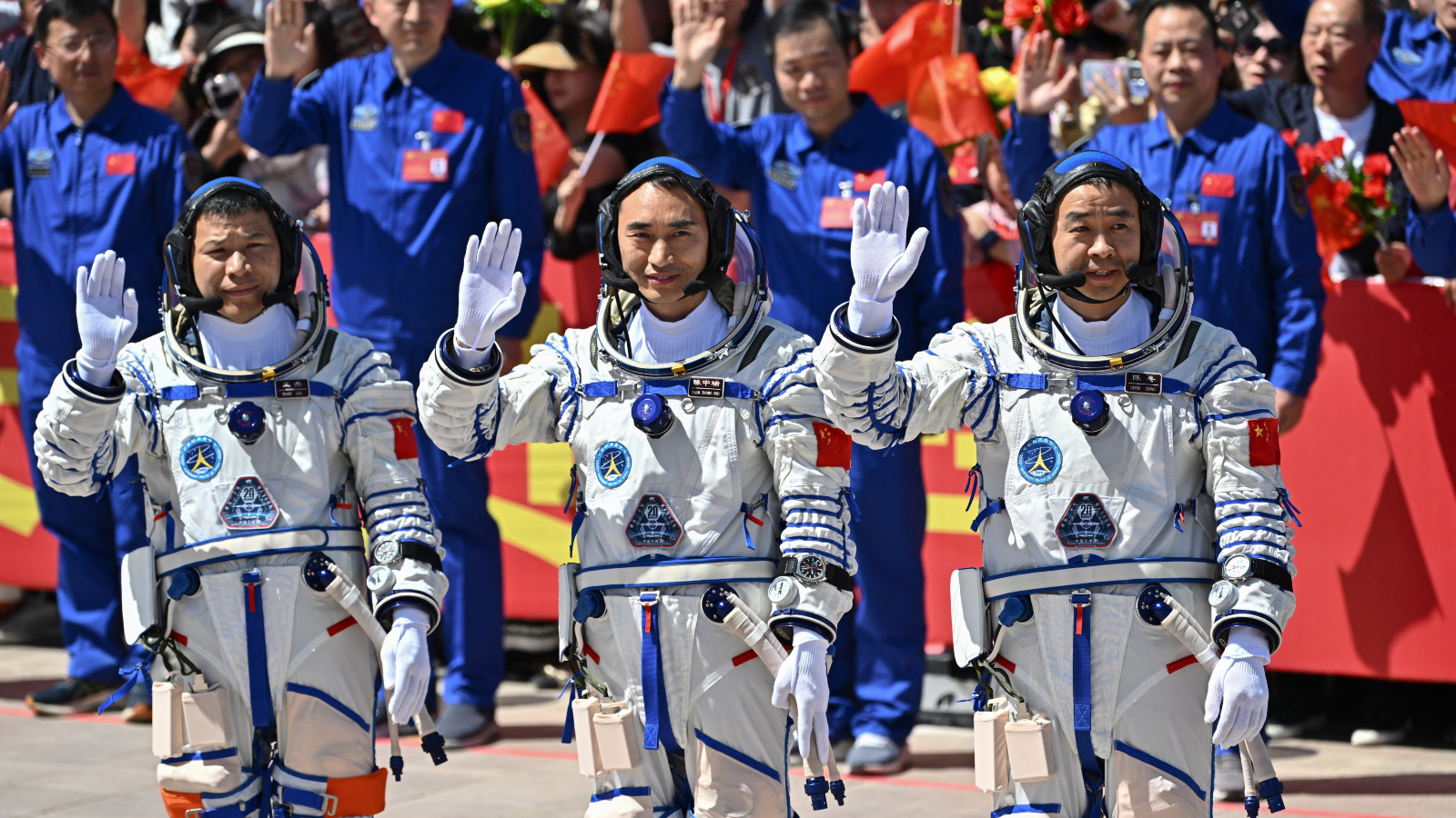 Foto de tres astronautas chinos saludando a las cámaras antes de lanzarse al espacio