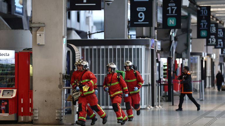 Los bomberos franceses corren por el vestíbulo de la estación. Imagen: Reuters