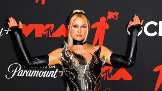 Paris Hilton, fotografiada en el desfile de moda de Anand John el 18 de septiembre de 2000, conversa con el actual presidente Donald Trump y Maxwell. (REUTERS)