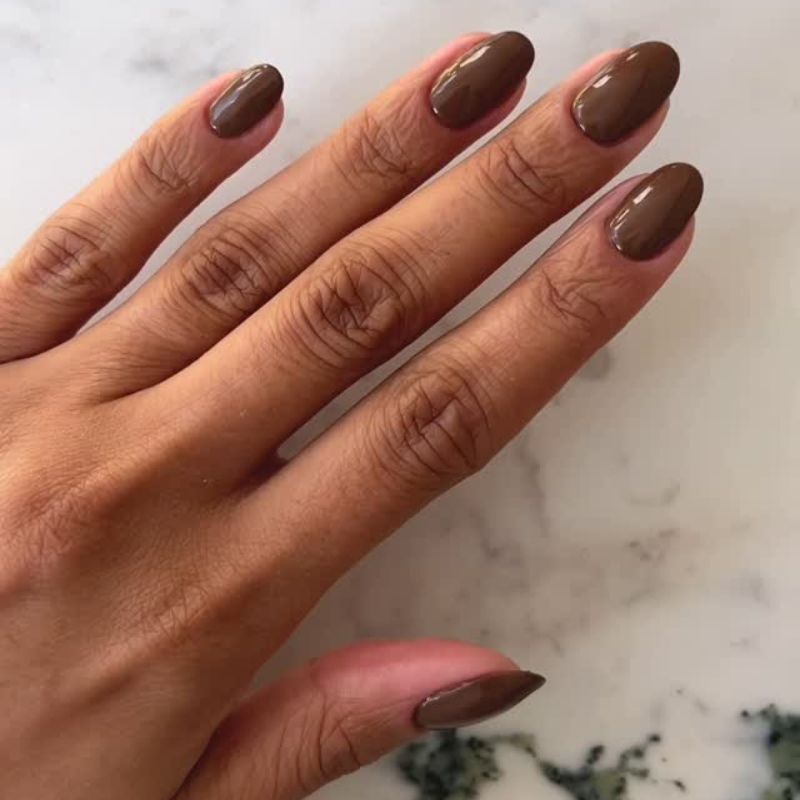 Un primer plano de la manicura marrón chocolate de @iramshelton