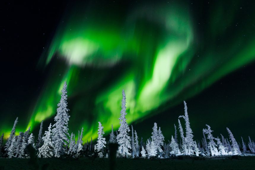 La aurora boreal, vista aquí al norte de Inuvik en los Territorios del Noroeste de Canadá, ocurre cuando partículas energéticas provenientes de eyecciones de masa coronal alcanzan el campo magnético de la Tierra e interactúan con los gases atmosféricos.