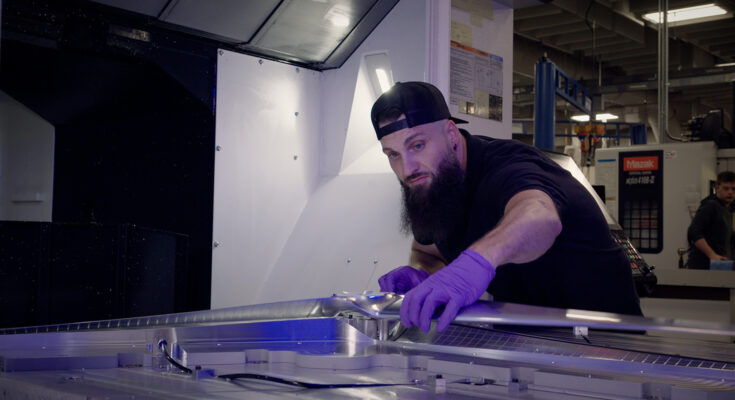 Experimental machinist Cory Pennington examines a freshly milled, full-scale Dragonfly rotor