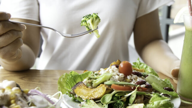 Enfoque selectivo de mujer con brócoli y ensalada.
