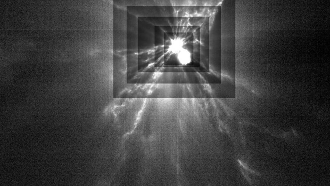Una imagen en blanco y negro muestra dos pequeñas esferas brillantes que chocan entre sí con rayos blancos que emanan de la colisión. 